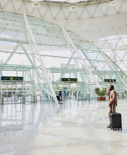 businessman talking on phone in airport terminal after arriving on flight