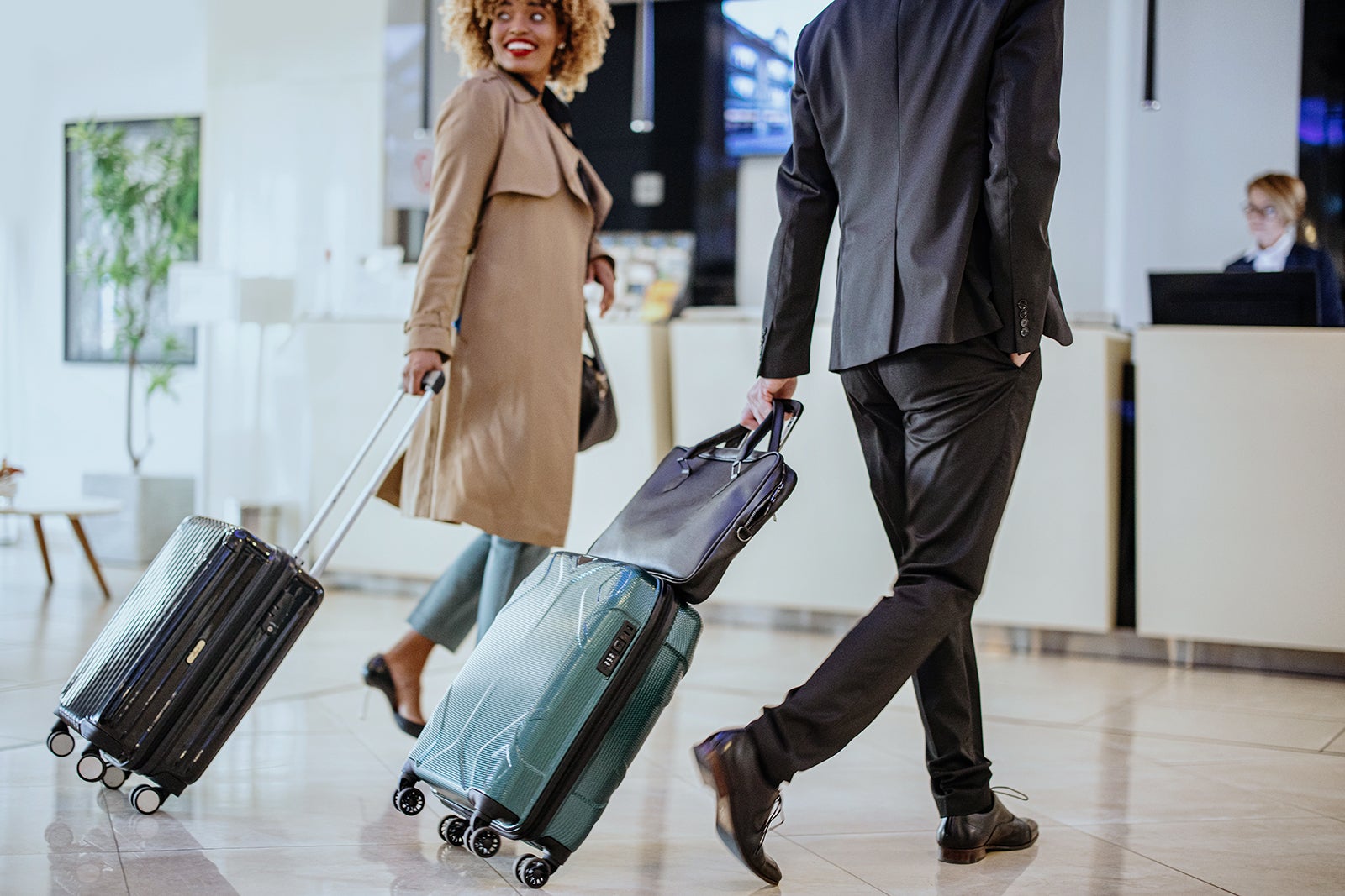 Business travelers with suitcases walking towards reception