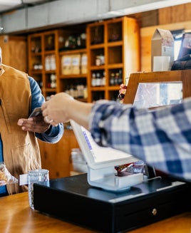 Senior man making purchase with credit card at cash register