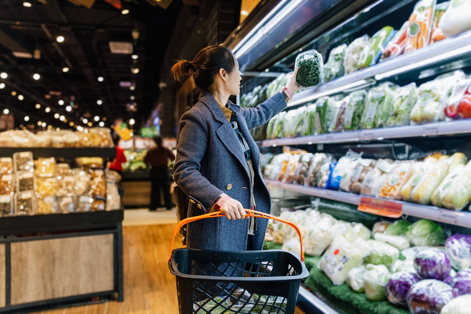 person looking at produce in grocery store