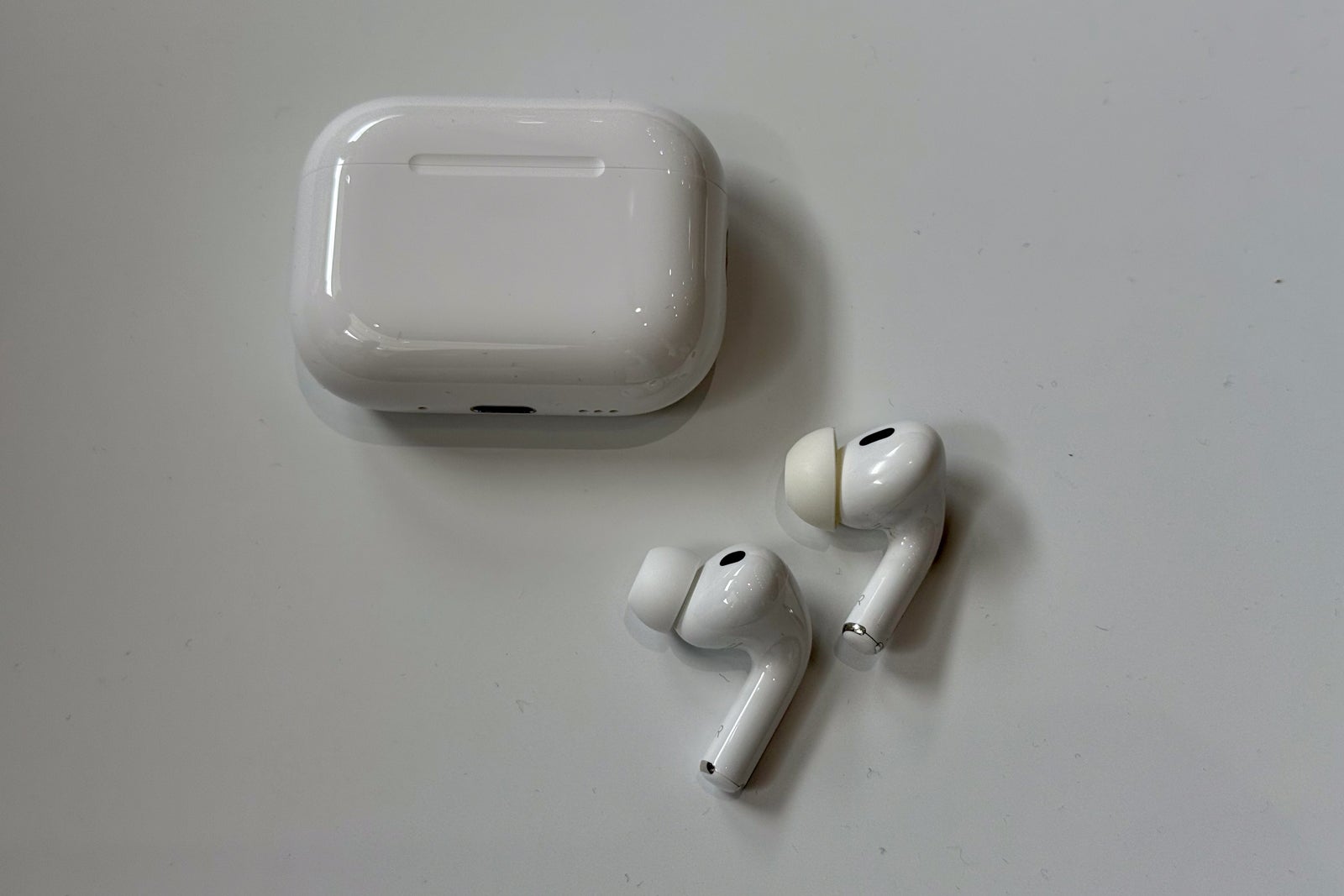 AirPods with a case sitting on a white table