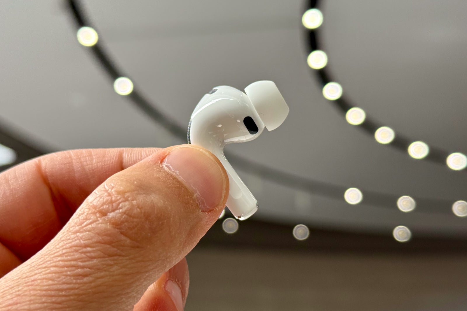 fingers holding an AirPod