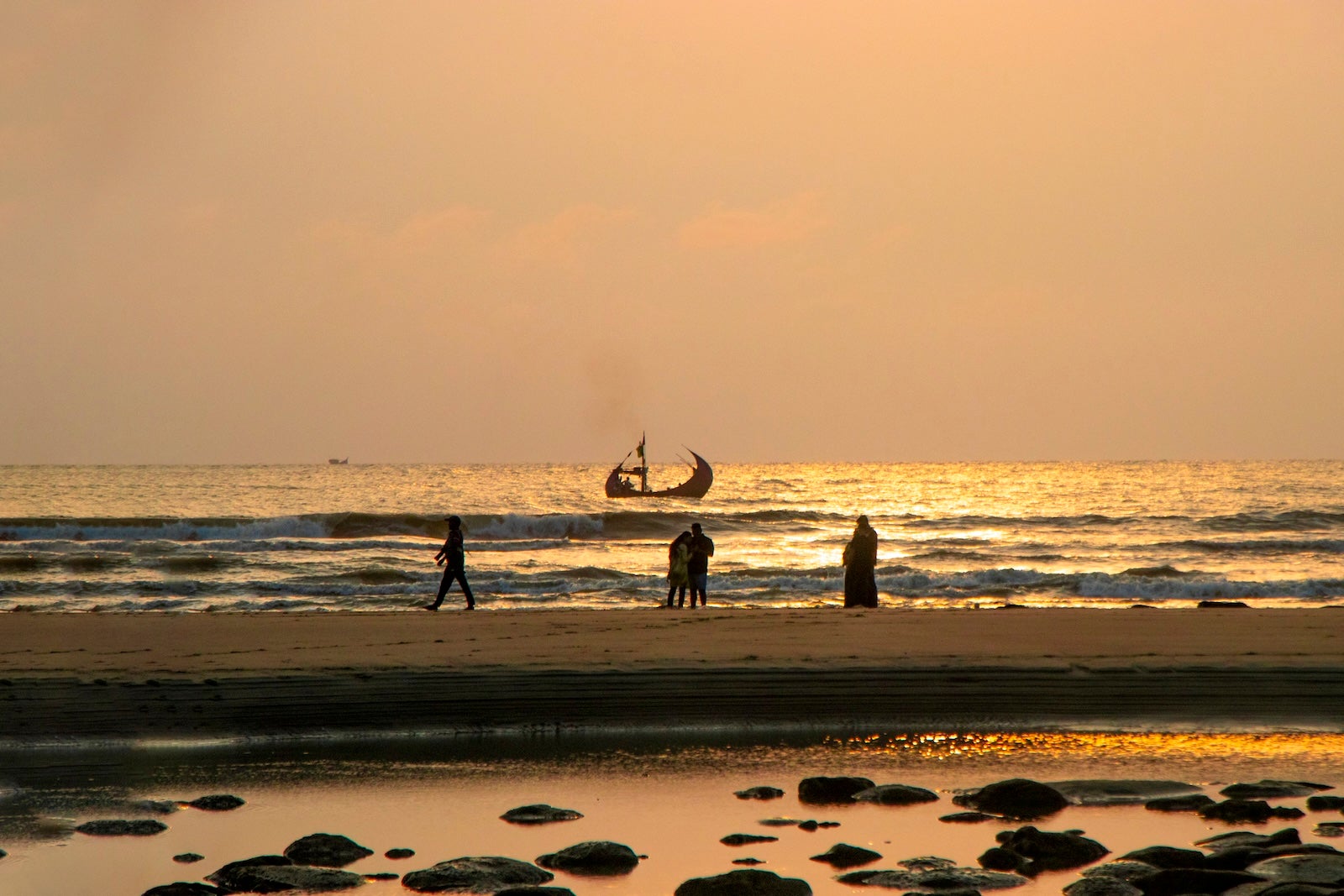 sunset at the Bay of Bengal, with vibrant hues of orange, pink, and purple blending seamlessly into the tranquil sea.
