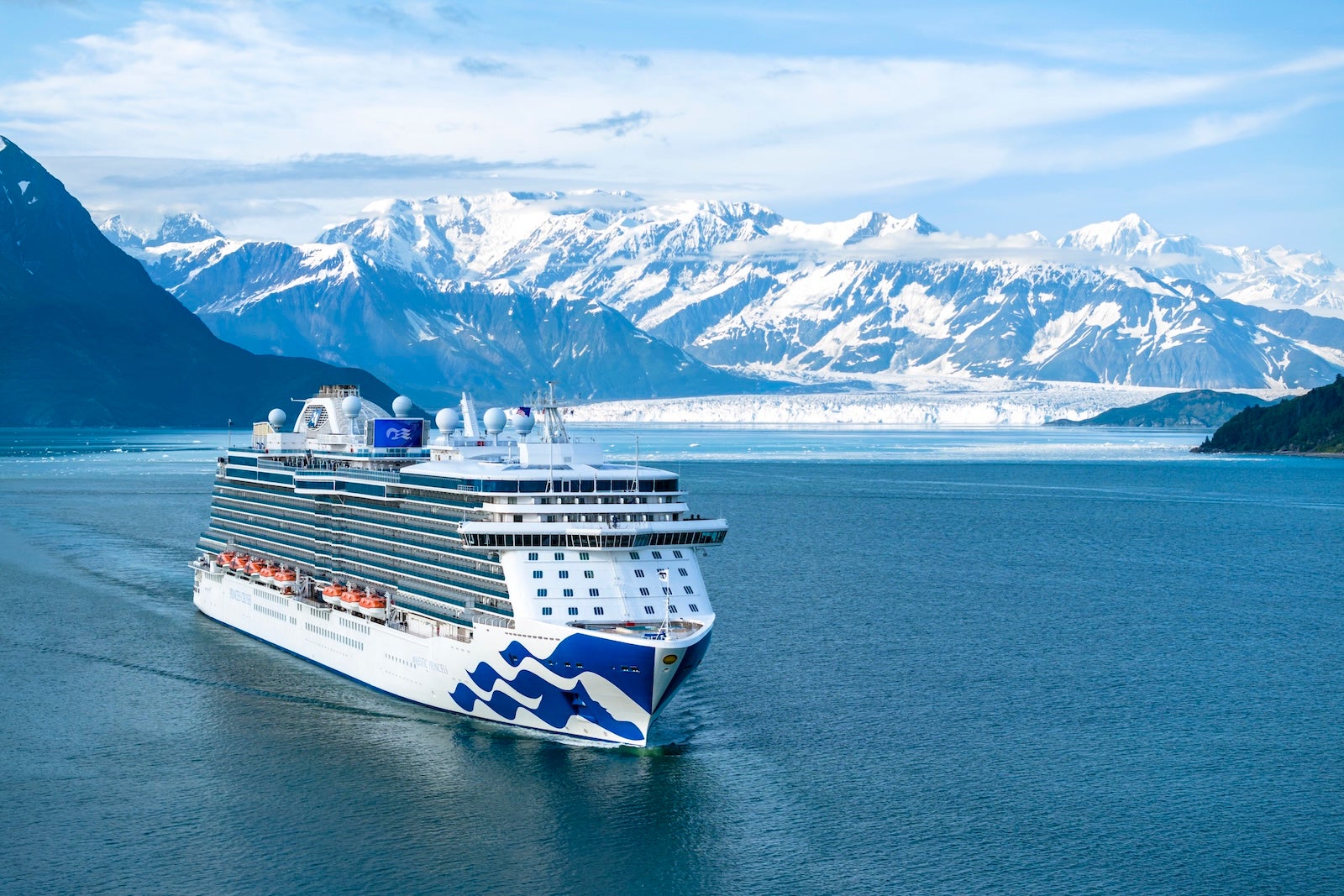 cruise ship with snow covered mountains in the background