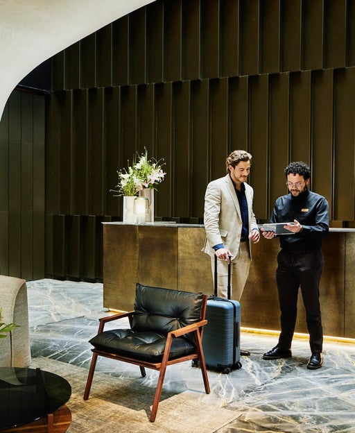 The lobby of a hotel with a business traveler checking in