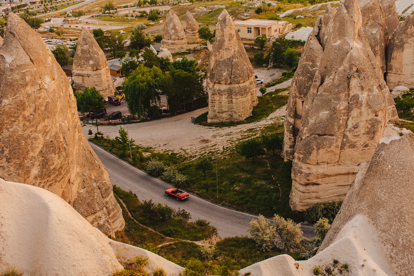 View of car passing in the road between big rock formations in Goreme, Cappadocia, Turkey