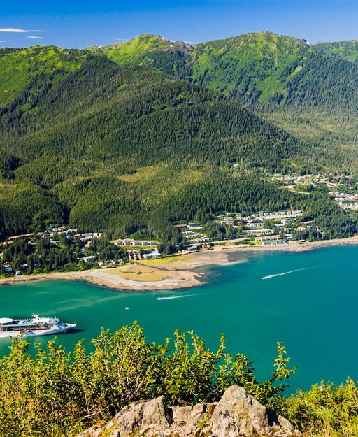 A luxury cruise ship sails along a narrow straight to reach Juneau, Alaska. on an August morning.