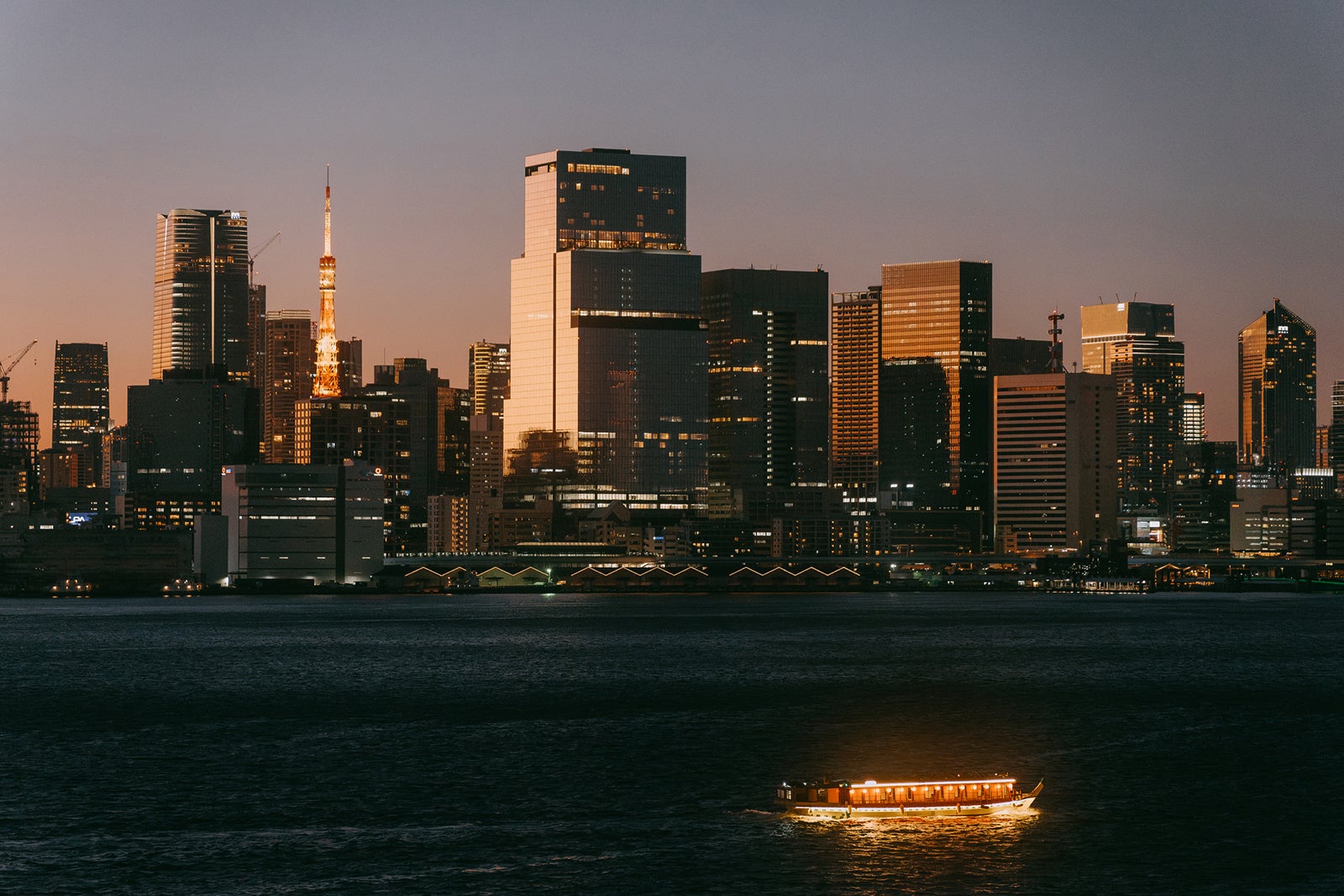 Tokyo cityscape with Tokyo Tower and boat, seen from Tokyo Bay at twilight