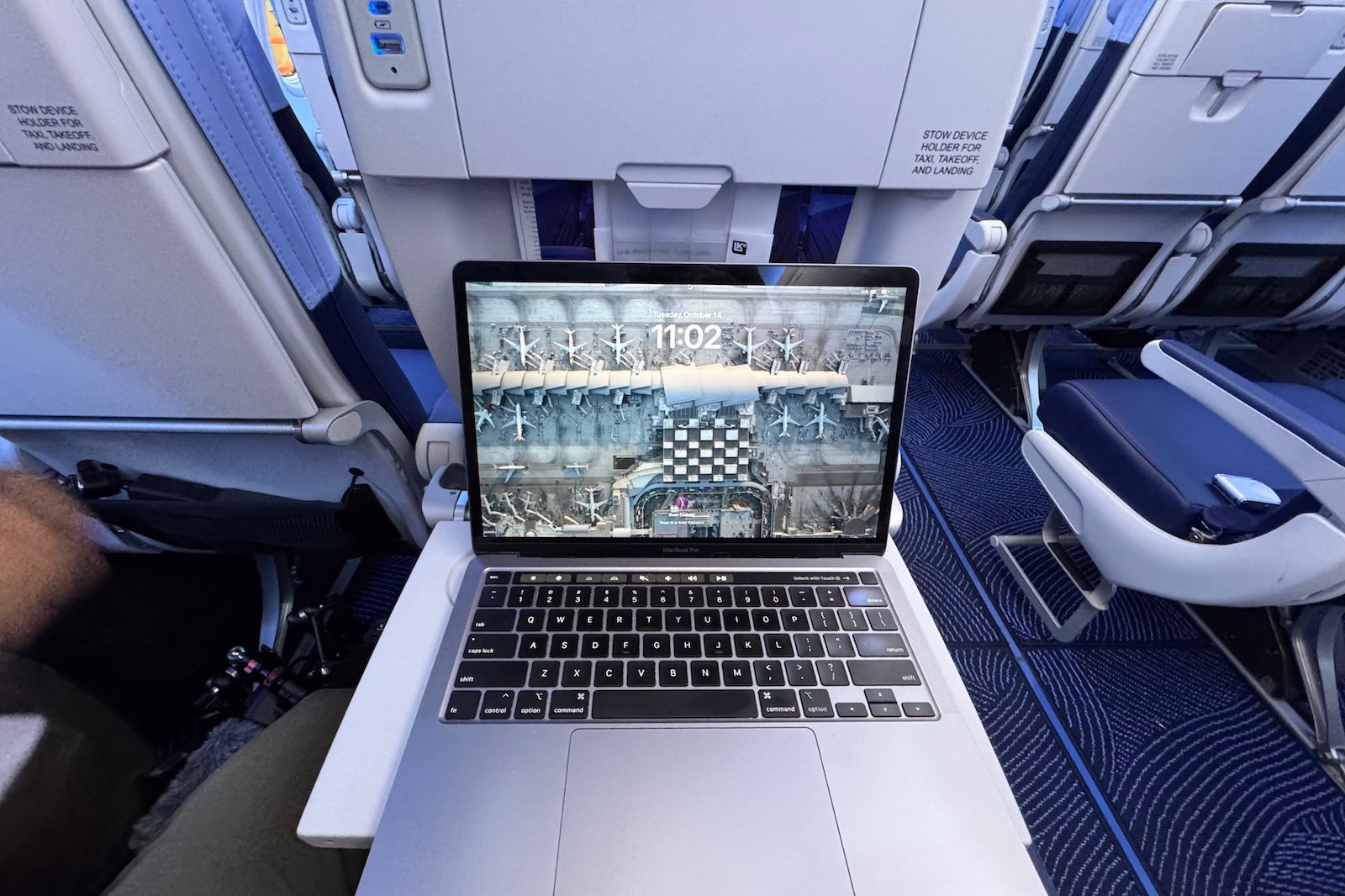 a laptop computer open on the seatback tray table