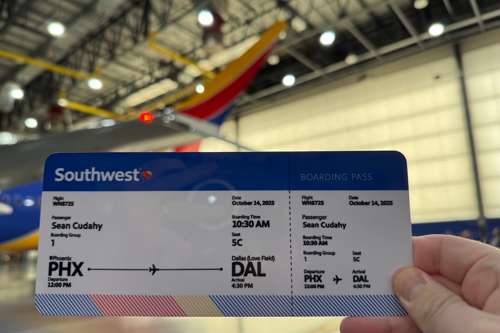 a hand holding a Southwest Airlines boarding pass
