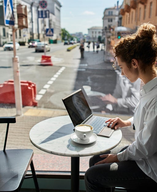 Young woman using laptop in a cafe