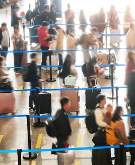 Crowded commuter people with luggage in airport waiting for check-in