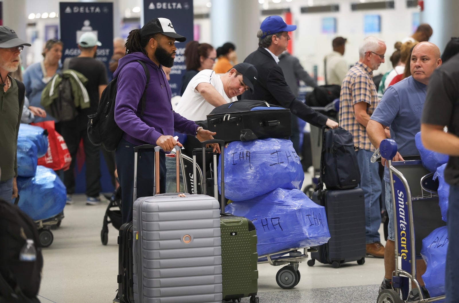 Travelers wait to check in at Miami International Airport (MIA)
