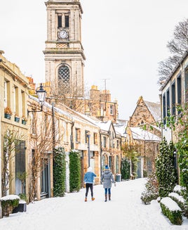 A view along a curving traditional mews street in Edinburgh's Stockbridge following heavy snow.