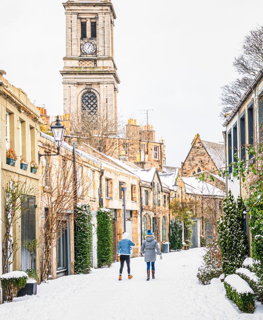 A view along a curving traditional mews street in Edinburgh's Stockbridge following heavy snow.