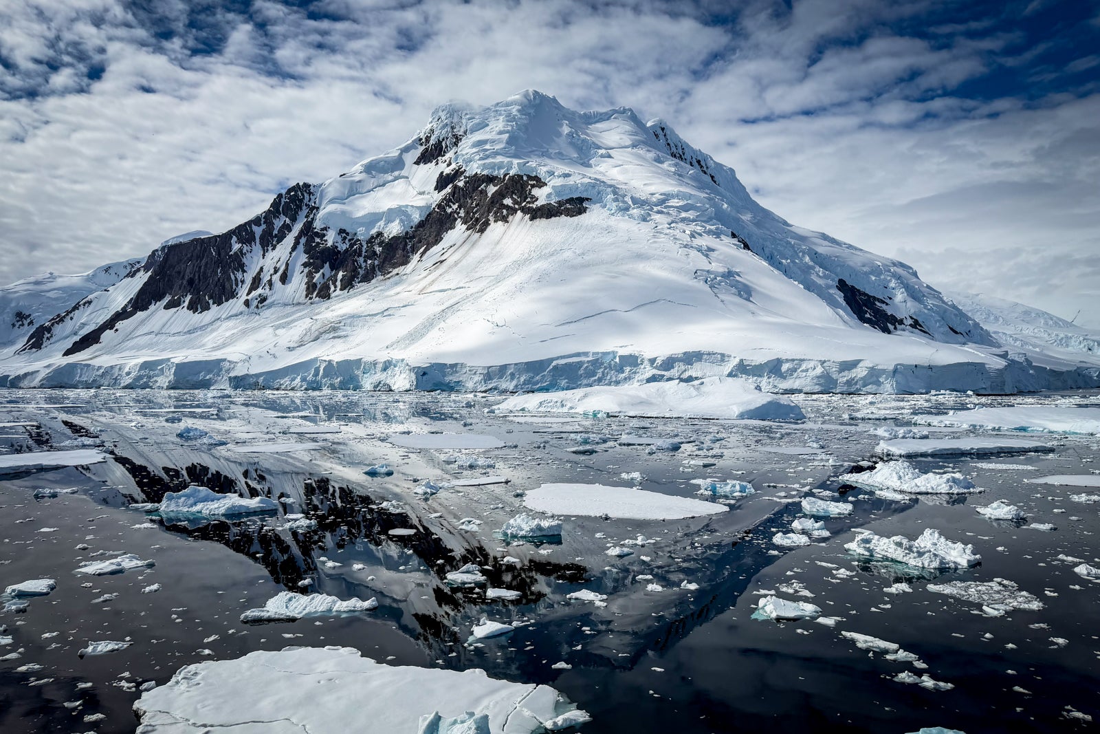 A stunning scene of snow-capped mountains, glaciers and ice in the water at a part of Antarctica known as The Gullet.