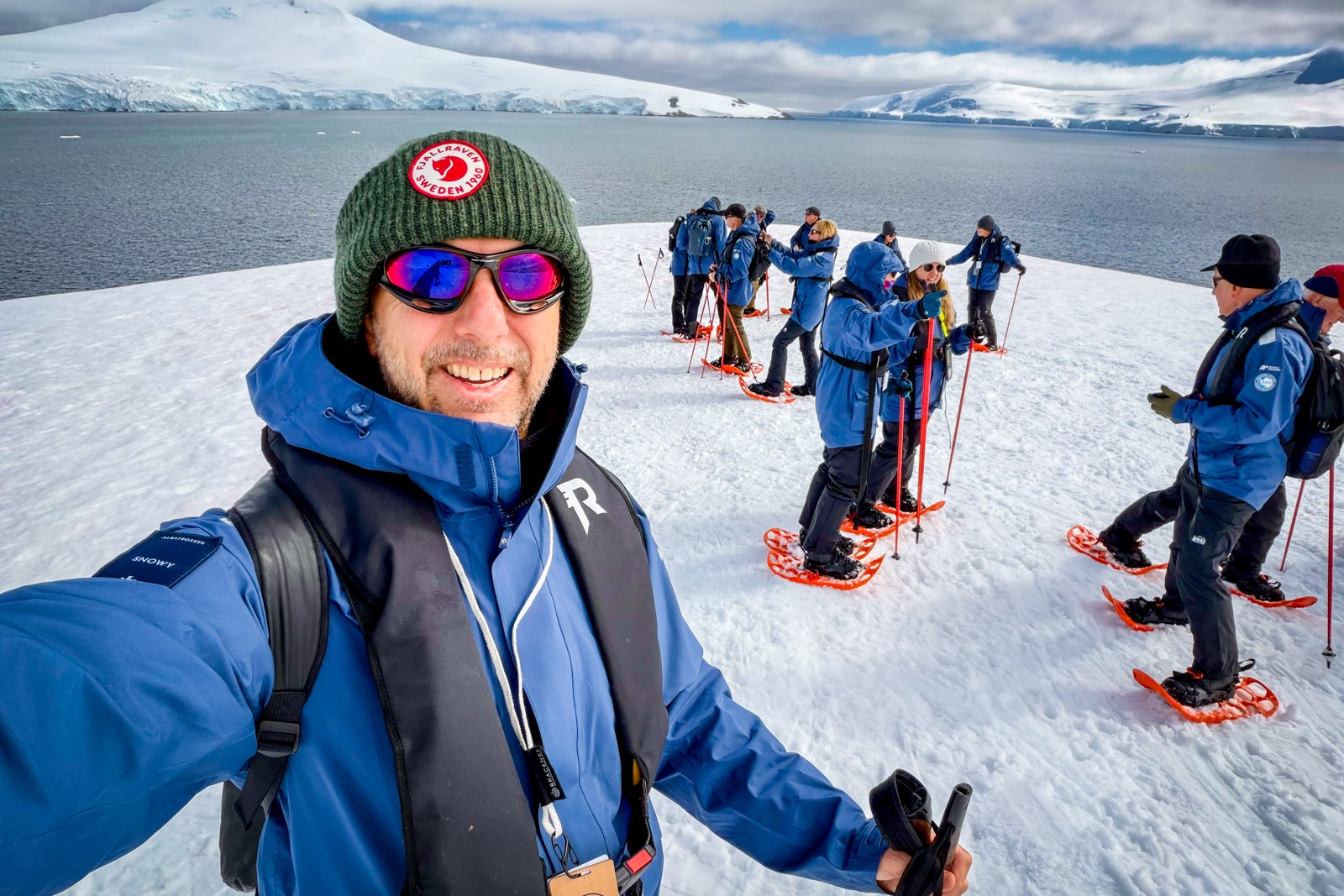 Passengers from the expedition cruise ship Roald Amundsen snowshoe in Antarctica.