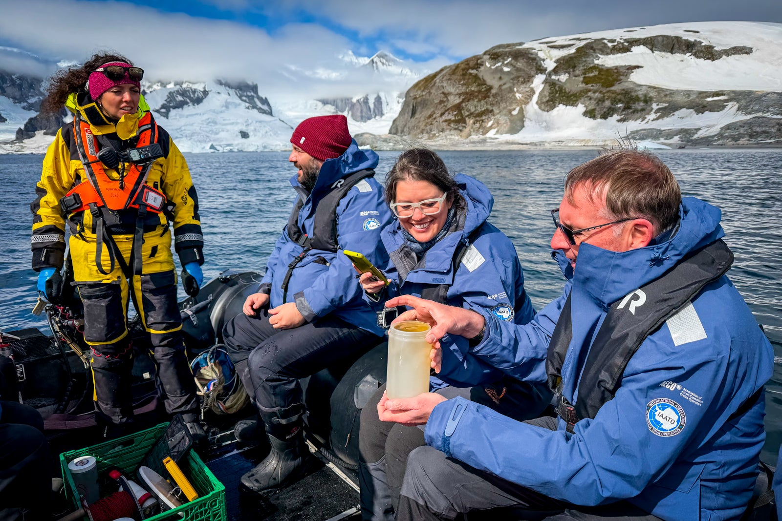 An HX Expeditions guide leads passengers on a "science boat" outing to collect water samples during an adventure cruise in Antarctica.