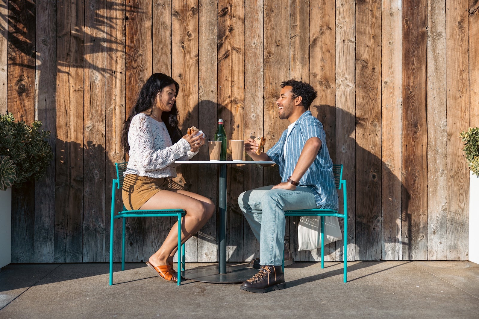 Couple eat a sandwich together.