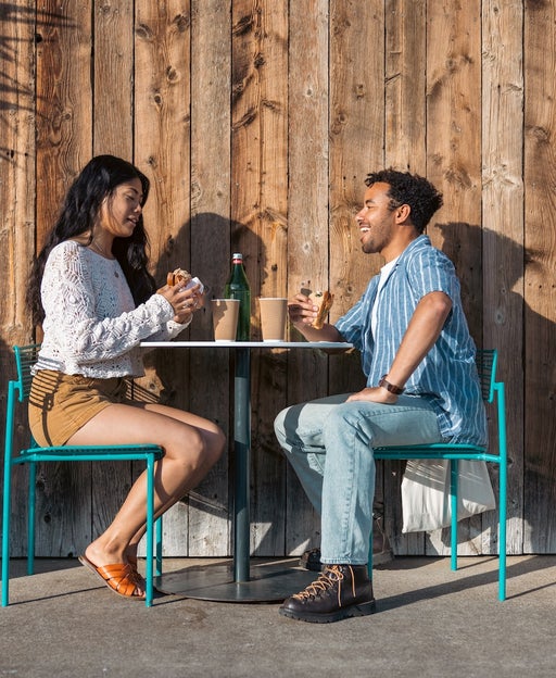 Couple eat a sandwich together.