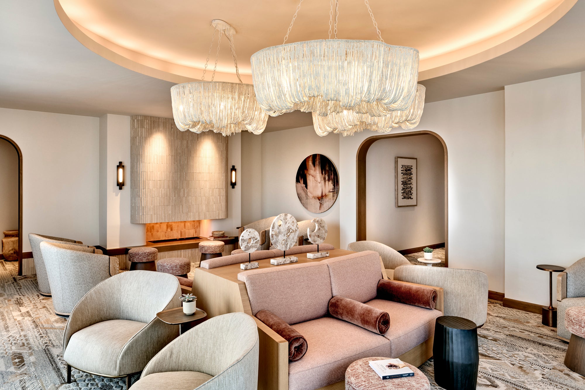 Women's lounge with fireplace, chandeliers and blush desert tones at JW Marriott Camelback Inn Spa