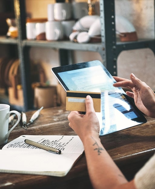 Cropped shot of an unrecognizable business owner sitting alone in her studio and using a tablet for online shopping