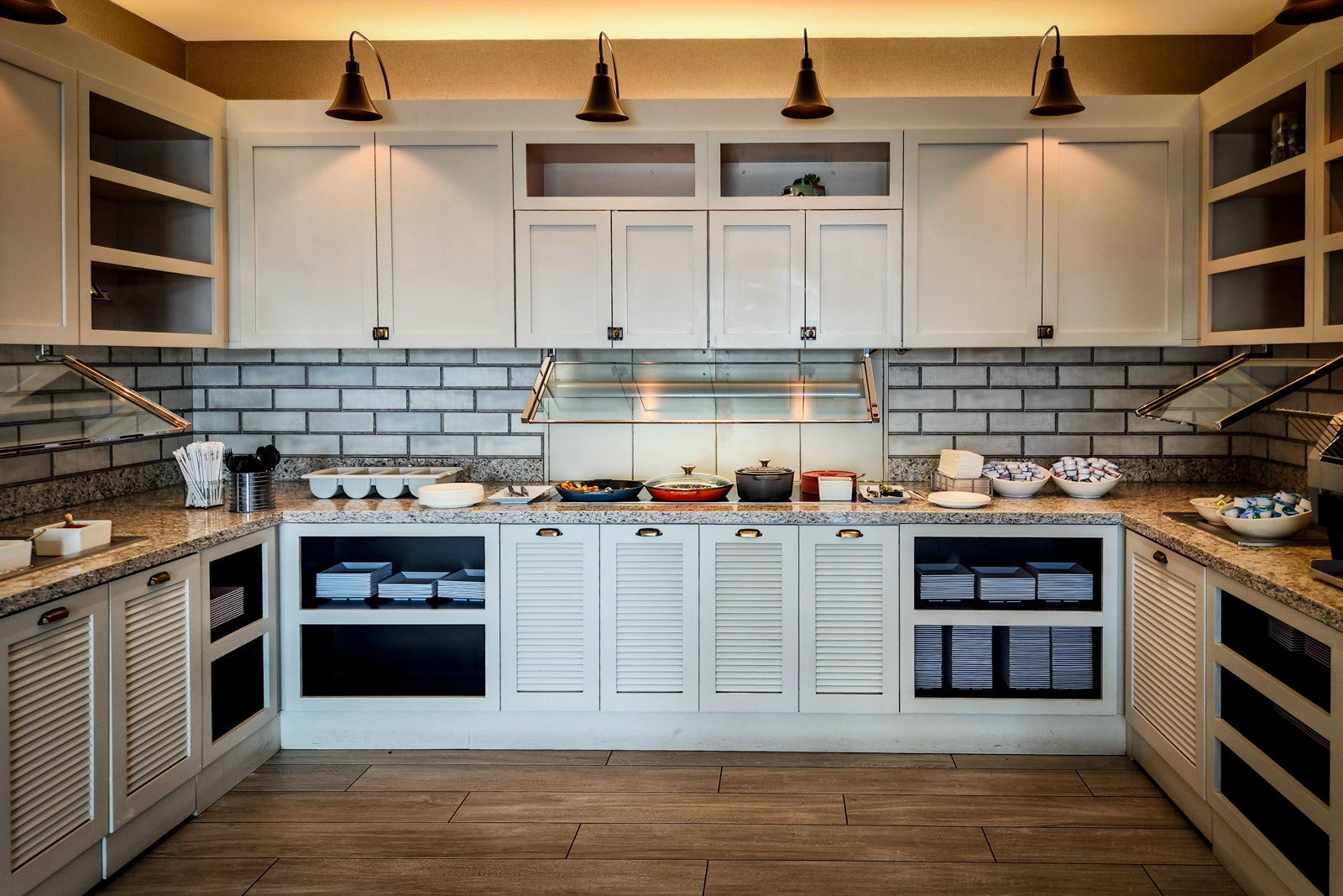 hotel breakfast buffet arranged on white cabinets