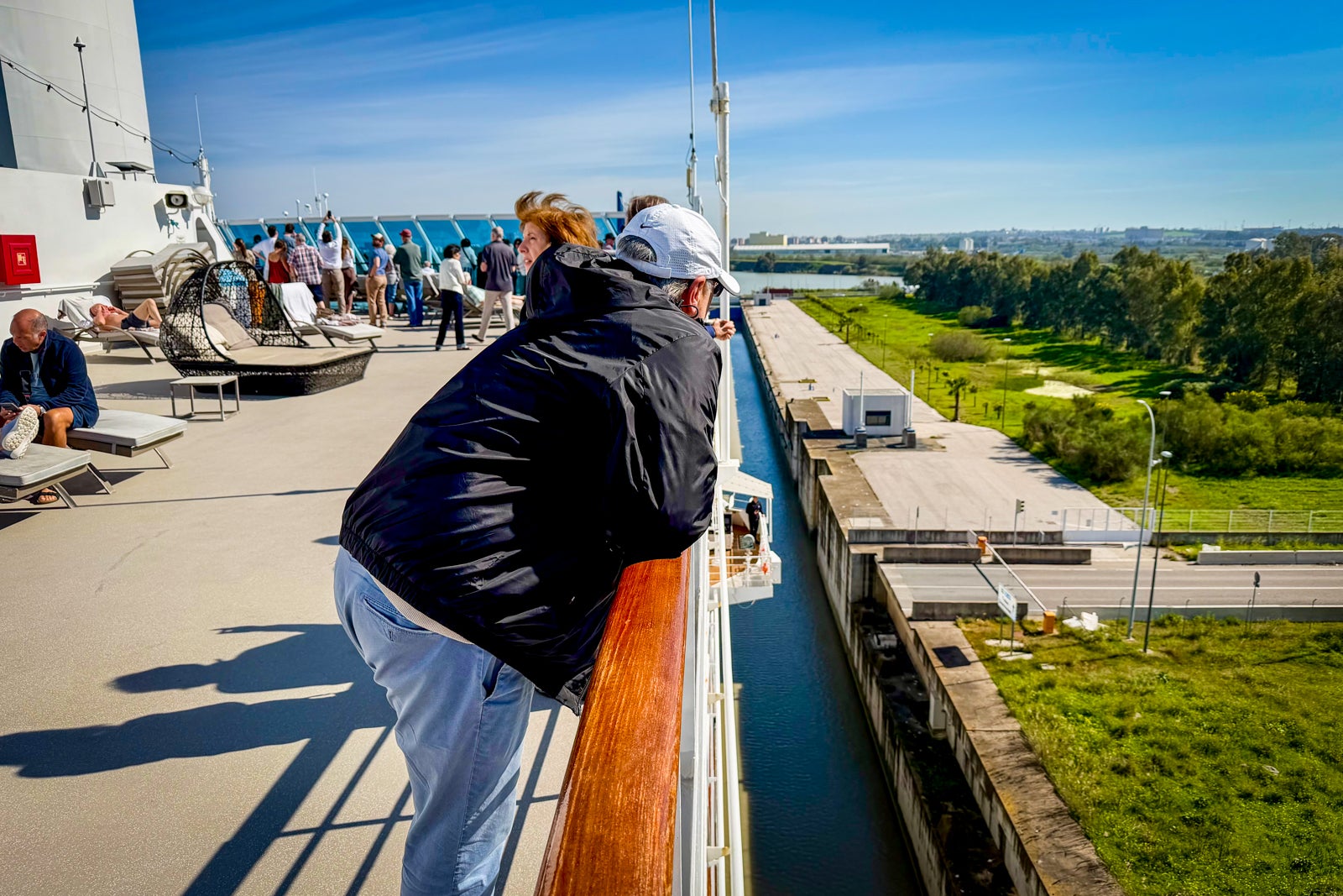 Passengers watch from a top deck as Azamara Journey travels through a river lock to reach Seville.