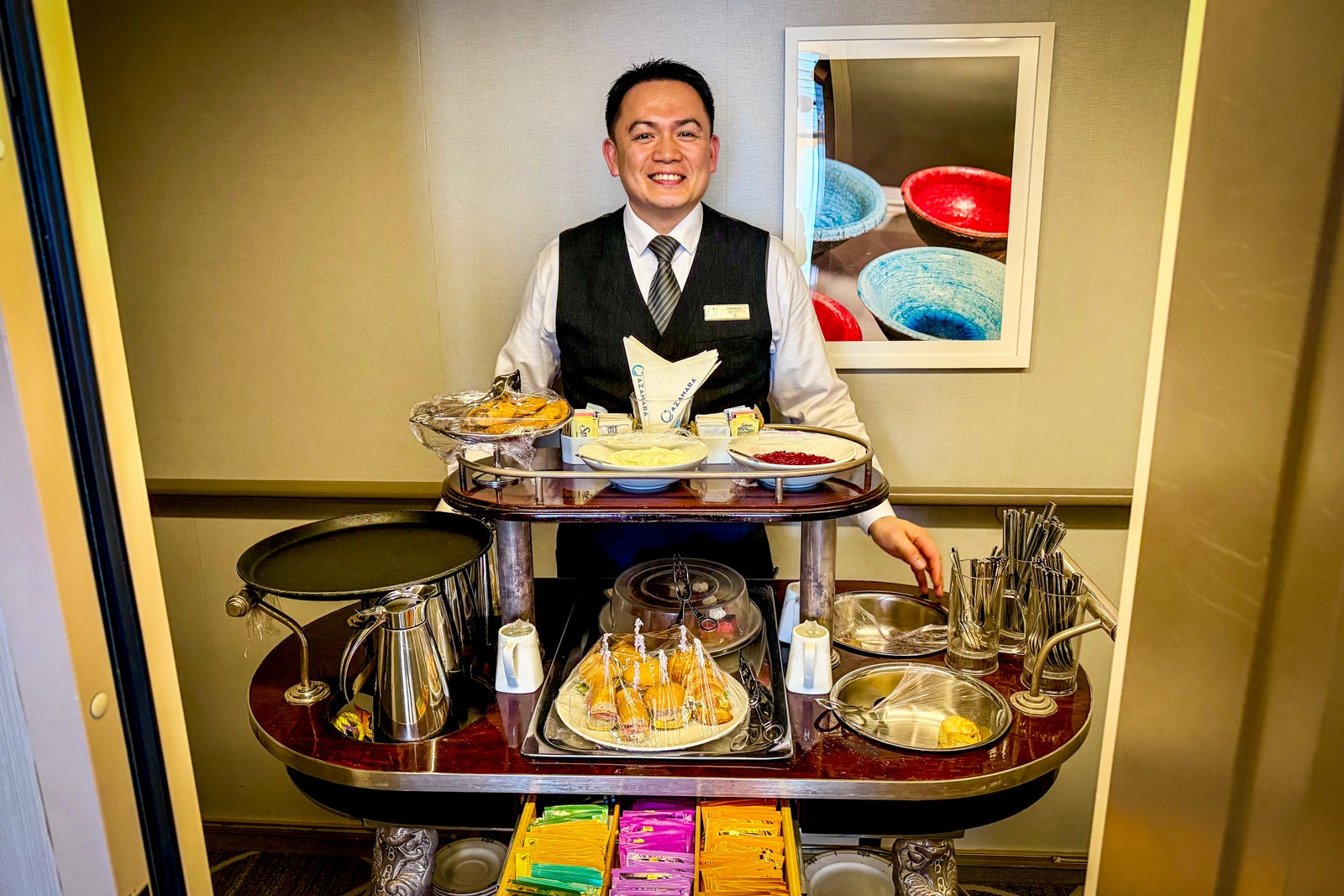 A butler brings tea and scones to passengers in suites.