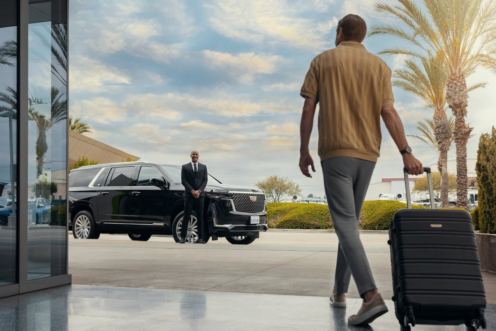 man walking toward car with luggauge