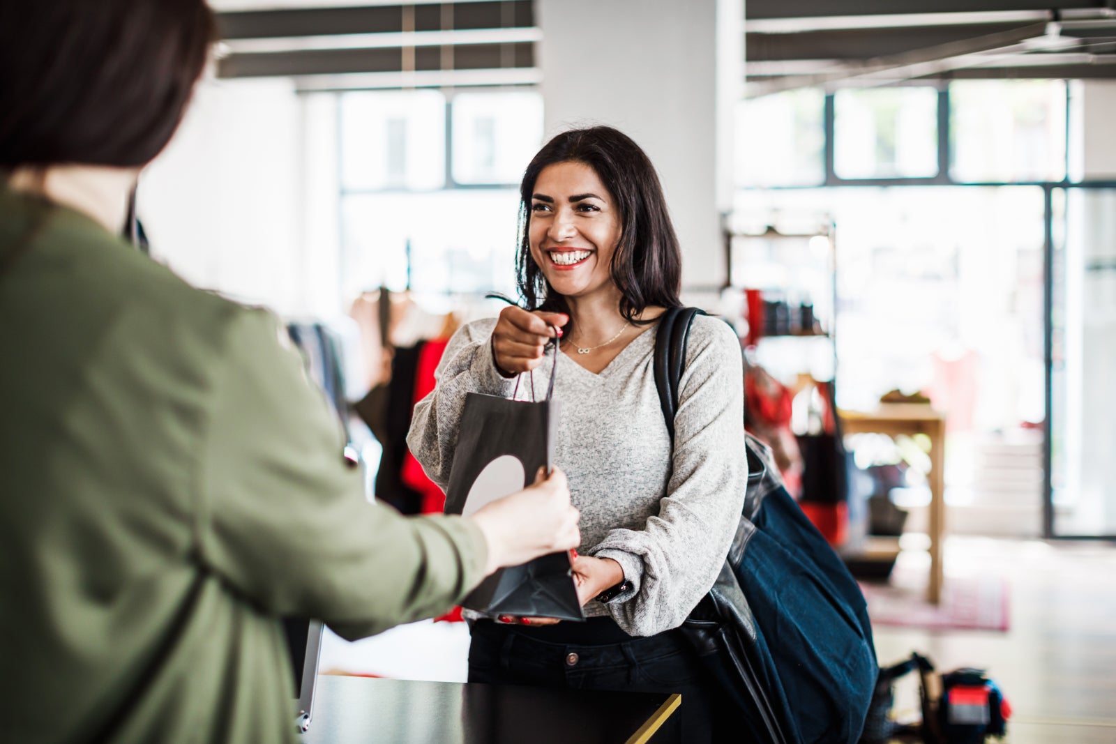 Store Clerk Handing Customer Purchased Items