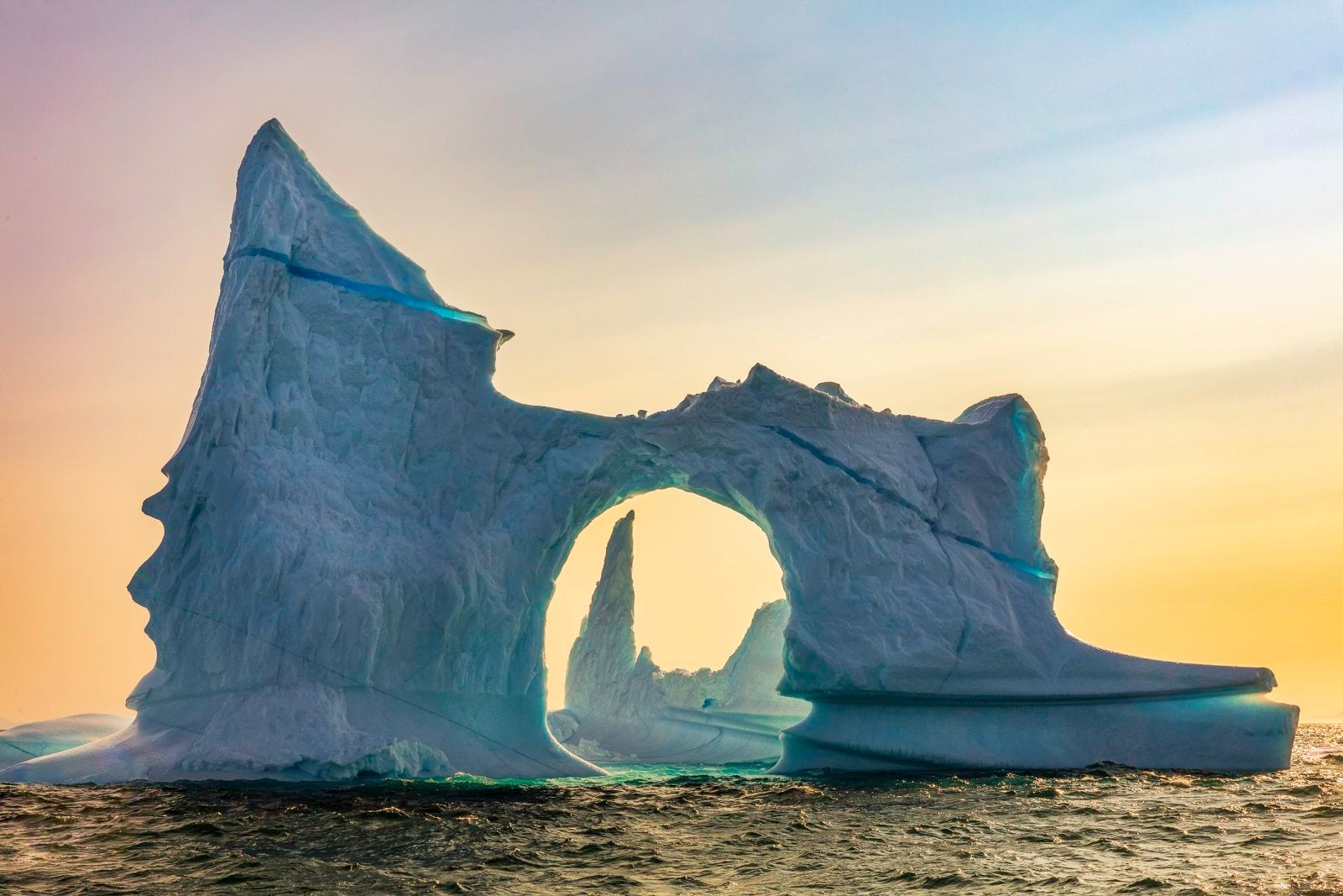 Beautiful Sky Serves As Backdrop For Two Uniquely Shaped Icebergs in Greenland's Scoresby Sound
