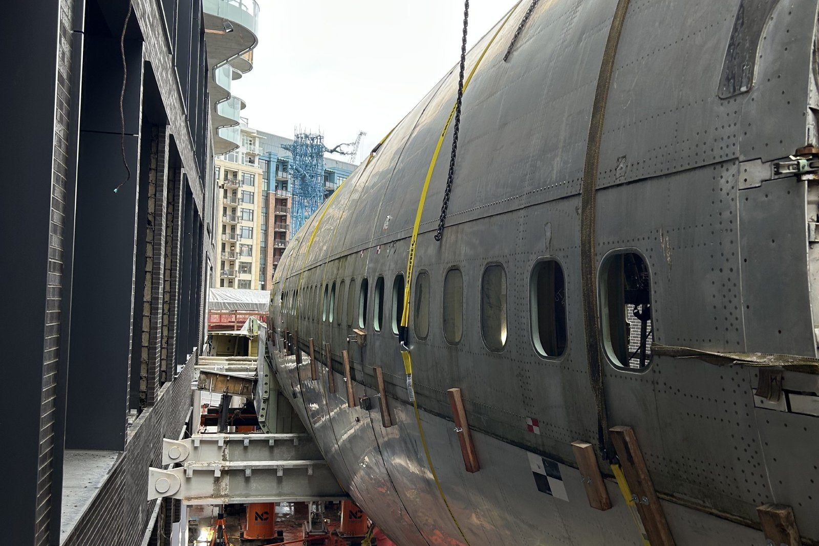 747 fuselage suspended between two high rises in Seattle