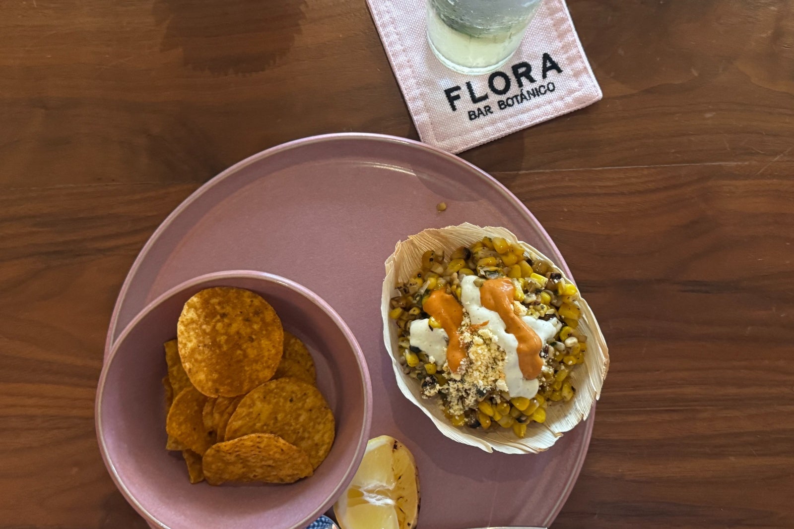 Pink plates with corn chips and corn dip at Flora Bar Botanico
