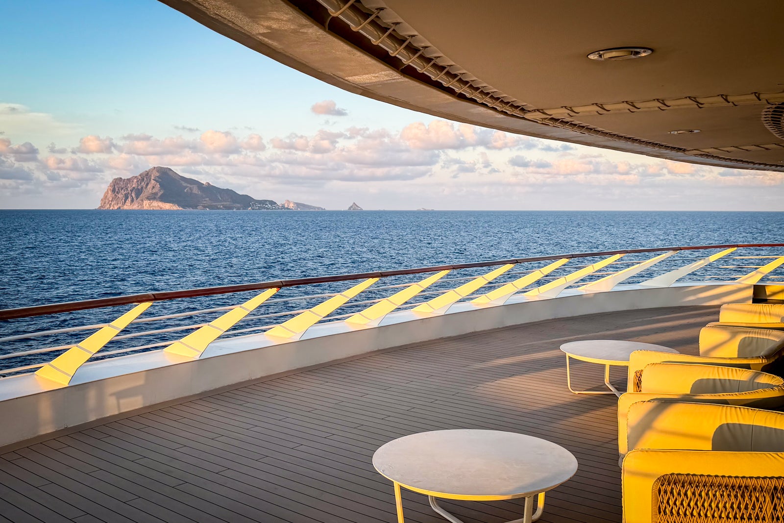 An outdoor lounge area at the front of the ship offers views of the sea.